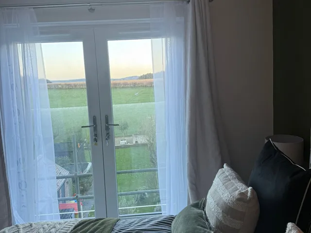 Bedroom with French doors and a Juliet balcony looking out over open fields