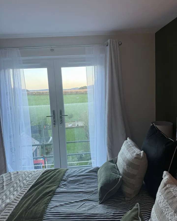 Bedroom with French doors and a Juliet balcony looking out over open fields